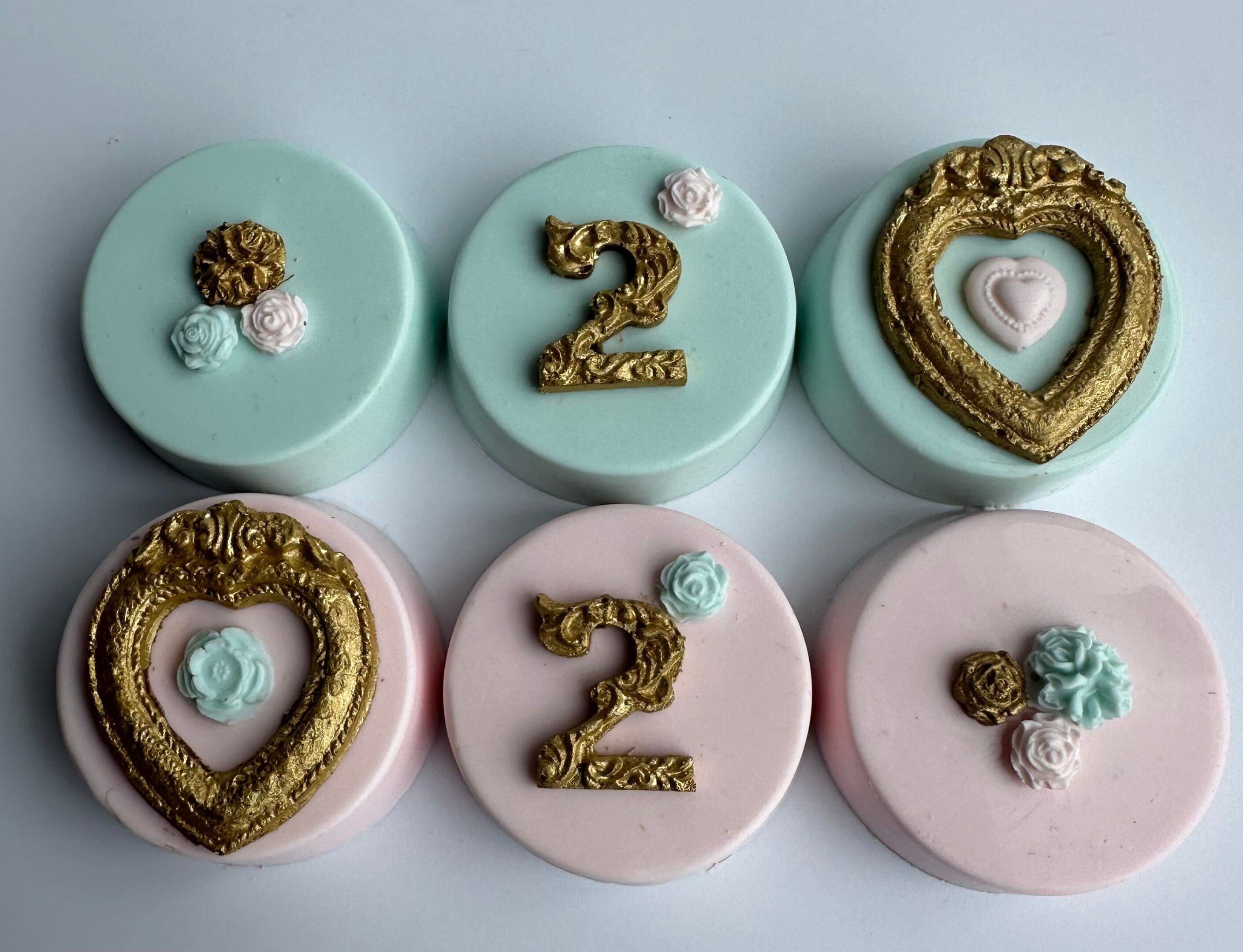 The set features six Gold Frame Chocolate Covered Oreos, three green and three pink, with ornate gold "2"s and heart-shaped frames, adorned with small floral decorations. Perfect for a girl's or boy's birthday celebration.
