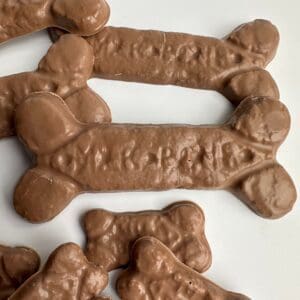 6-bags of chocolate dog bones for birthday/gag gift/treats scattered on a white surface.