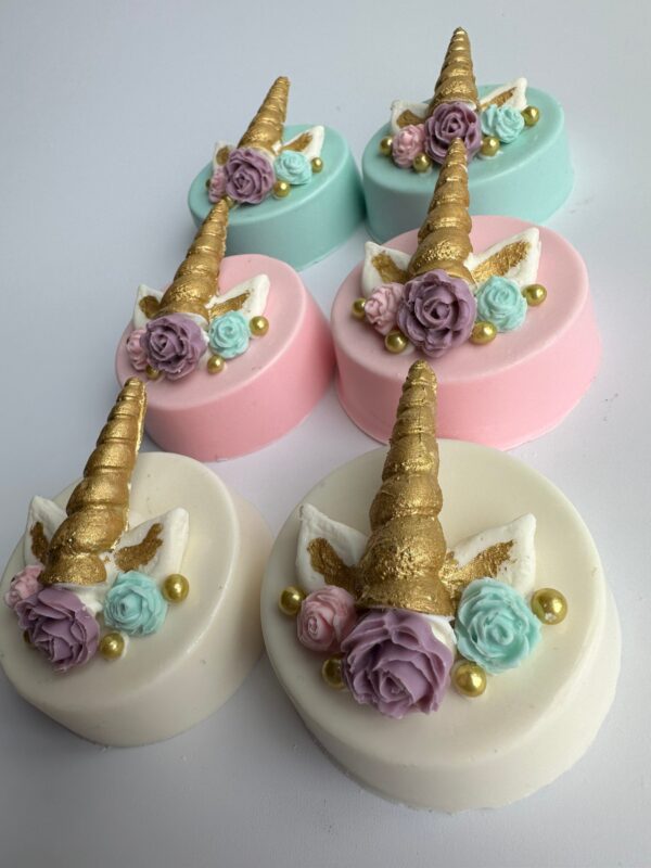 Unicorn-themed round cakes feature chocolate-covered Oreos adorned with unicorn horns, ears, and pastel flowers in pink, white, and mint green.