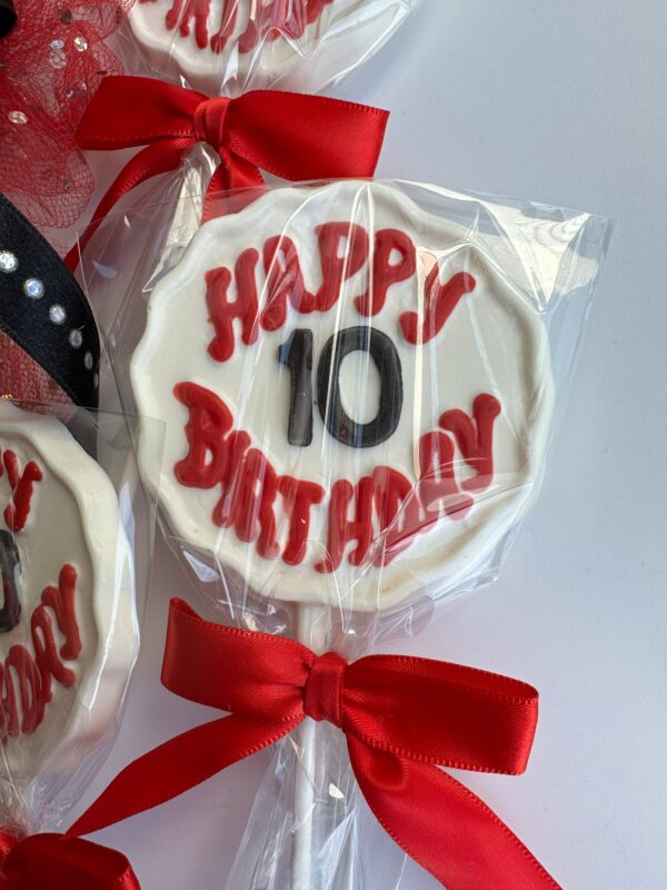 12-Happy Birthday Chocolate Lollipops with age, designed like lollipops with "Happy 10 Birthday" in red and white icing, wrapped in clear plastic and tied with red ribbons.