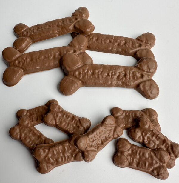 6-Bags of chocolate dog bones for birthday gifts or treats are arranged on a white surface.