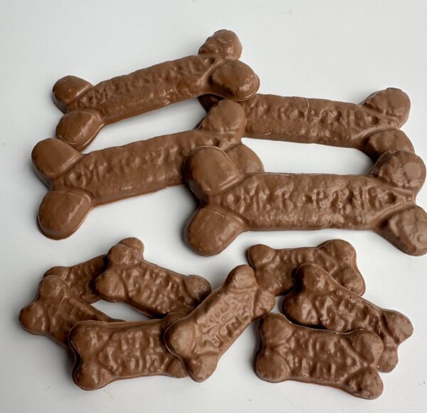 A set of six bags labeled "6-Bags of Chocolate Dog Bones For Birthday/ Gag Gift/Treats" is arranged on a white surface.