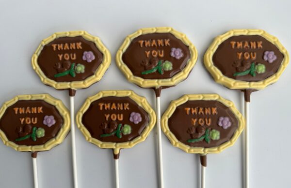 Six "Thank You" chocolate lollipops from the 12-Thank You Chocolate Lollipops set, each adorned with a small flower and border.