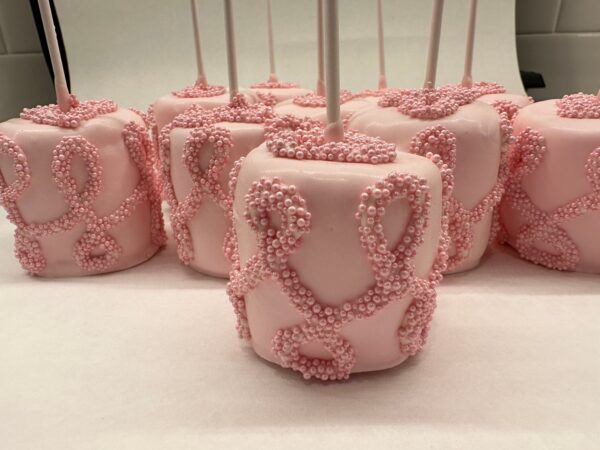 Pink candy apples featuring intricate beaded decorations on sticks, elegantly displayed on a white surface from the Large Chocolate Treats Happy Birthday Box.