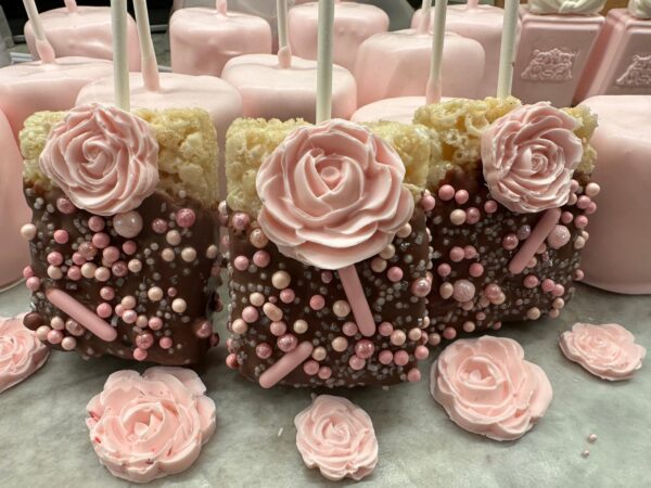 Chocolate-covered Rice Krispie treats, decorated with fondant rose designs and pink sugar pearls, from the "12 Chocolate Covered Rice Krispie Treats With Roses for Shower/Wedding/Birthday Party Favors" set.