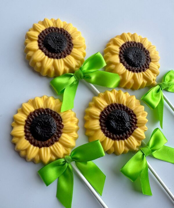 Four 24-Chocolate Sunflower Lollipops, featuring yellow petals, brown centers, and green bows on sticks, are arranged on a white background.