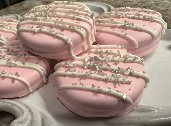 12-Pastel Pink Chocolate Covered Oreos with white drizzle and silver sprinkles, arranged on a white tray. Ideal for wedding or baby showers.