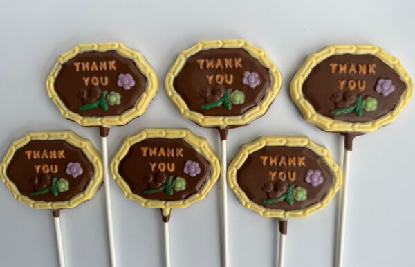 A set of six chocolate lollipops featuring a "Thank You" message and flower design on a white background from the 12-Thank You Chocolate Lollipops collection.