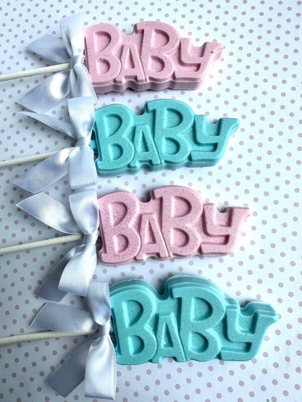 Pink and blue 24-BABY chocolate lollipops with white bows on a polka dot background for baby shower or party favors.