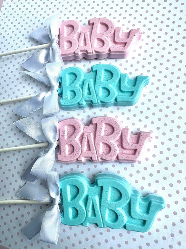 Four 24-BABY Chocolate Lollipops for baby showers, in pink and blue with white ribbons, arranged on a polka dot background.