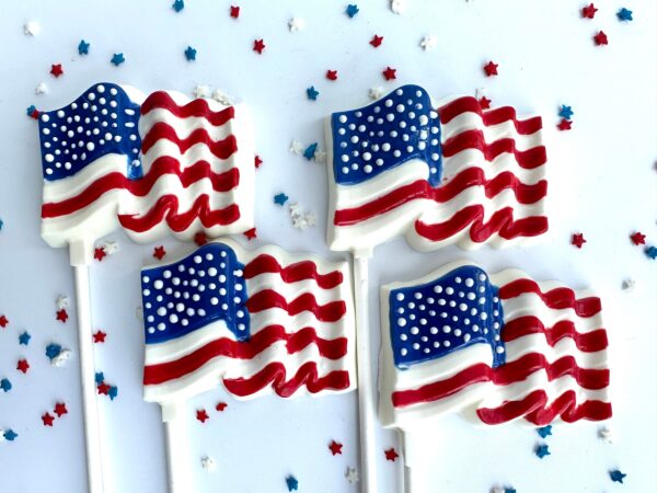 A set of 12 white chocolate American flag-themed lollipops features a patriotic design of red, white, and blue stars scattered over a pristine white background, perfect for Memorial Day or 4th of July celebrations.