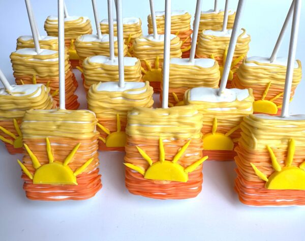 Sunset Ombré chocolate-covered Rice Krispie treats adorned with fondant suns, perfect for birthday parties or baby showers.