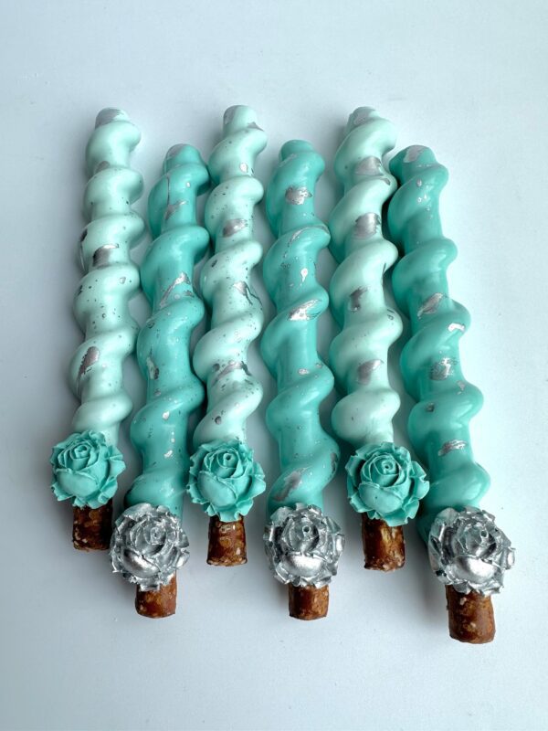 Twelve spiral caramel pretzel rods covered in Tiffany blue and white icing, adorned with silver speckles and flower decorations, ideal for weddings, showers, birthdays, and party favors.