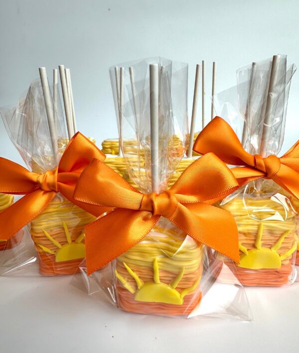 A set of 12 Sunset Ombré Chocolate Covered Rice Krispie Treats wrapped with orange bows and designed in orange and yellow hues, resembling a sunset. Perfect for birthdays, party favors, or baby showers.
