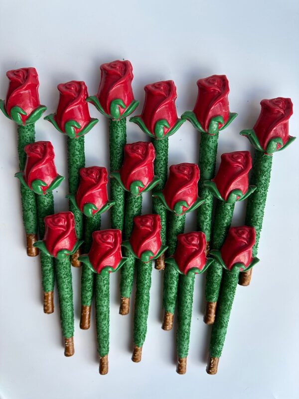 The 24-LONG STEM ROSES-Chocolate Covered Pretzel Rods are decorated as red roses with green leaves and arranged against a white background.