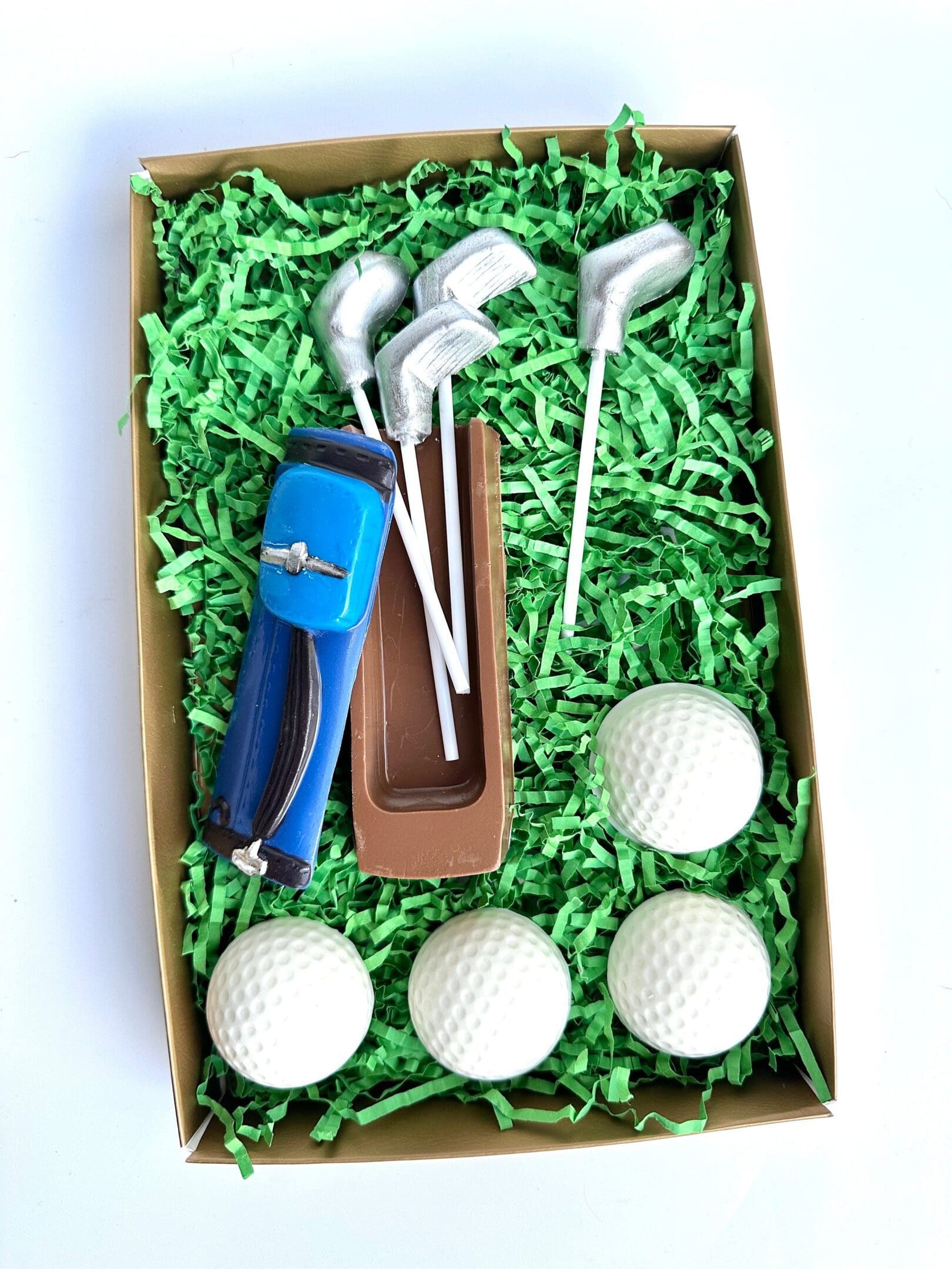 The Golf Bag With Clubs & Golf Balls Chocolate Gift Set features chocolate shaped like a golf bag, three clubs, and three golf balls on green shredded paper. Perfect for Dad Birthday Gift/Son Gift/Golf Gift.