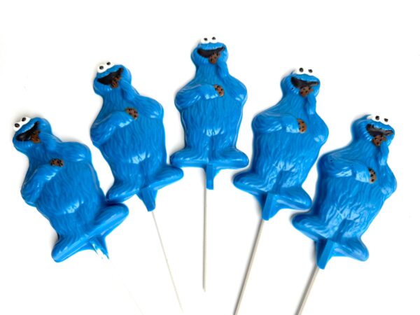 Five 12-Chocolate Blue Monster Lollipop Favors with eyes and cookies, on white sticks, arranged in a row on a white background.