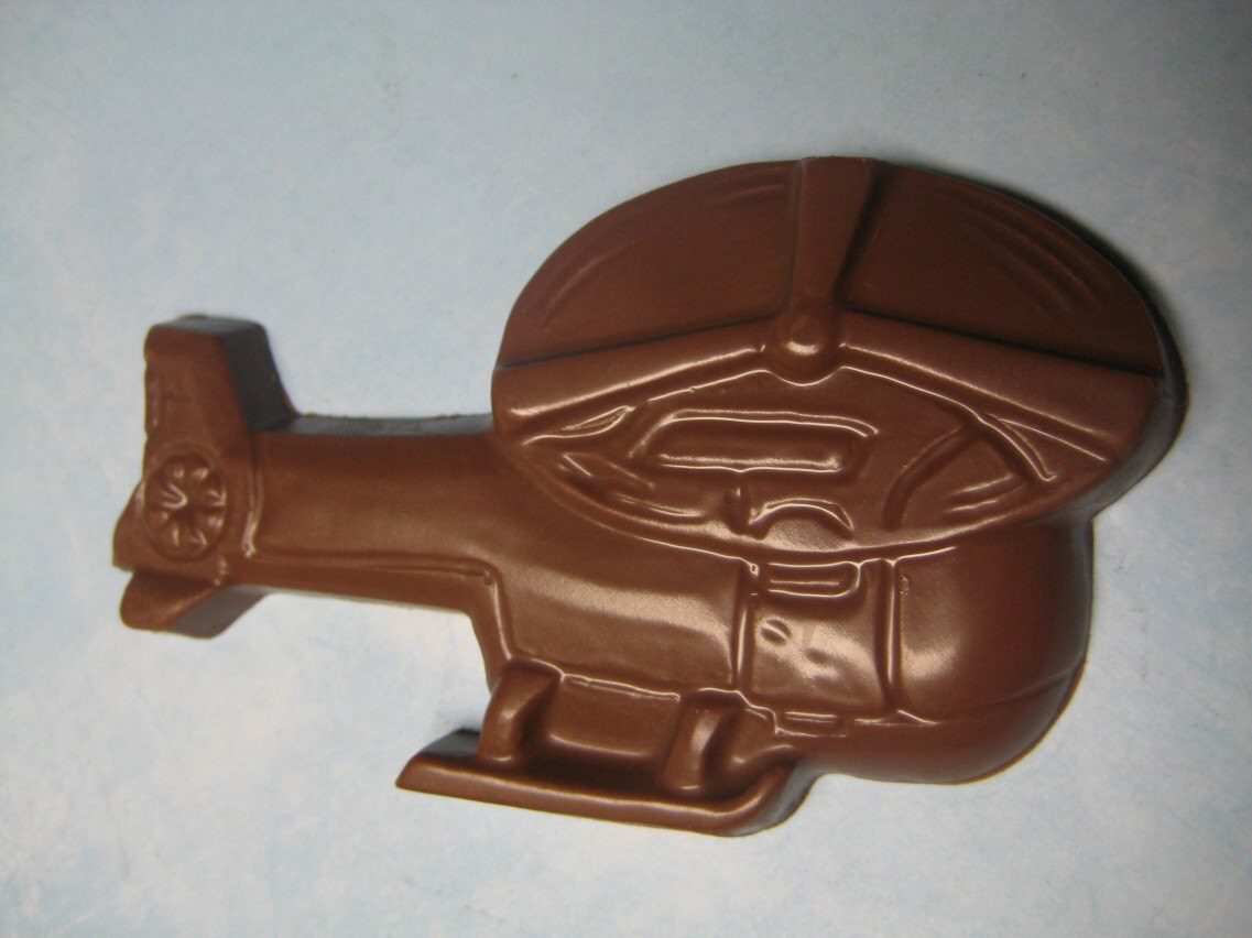 A 12-chocolate helicopter favor, featuring detailed rotor blades, tail, and landing skids set against a light blue background.