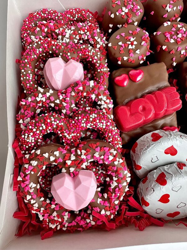 A Milk Chocolate Treat Gift Box for Valentine's Day featuring assorted heart-decorated chocolates and pretzels.