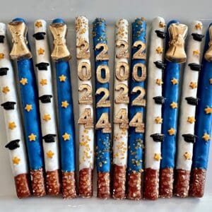 The 12-Graduation 2024 Gold Diploma Chocolate Covered Pretzel Rods feature blue, white, and red coatings with golden stars, graduation caps, and the numbers 2022 and 2024 in gold for your graduation party or favors.