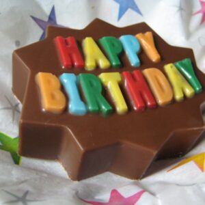 Star-shaped chocolate-covered Oreo with colorful "Happy Birthday" letters on a starry background.