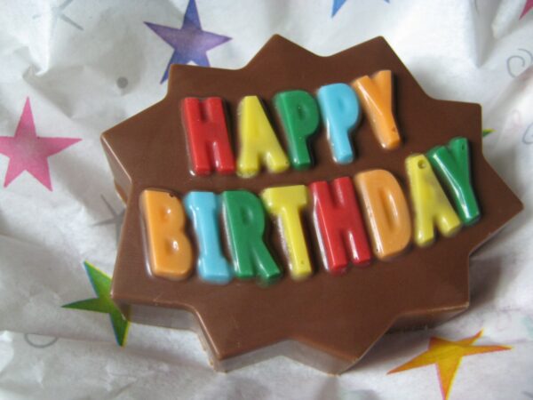 12-Happy Birthday Chocolate Covered Oreo Party Favors featuring colorful 'Happy Birthday' letters on a star-shaped background with star-patterned paper.