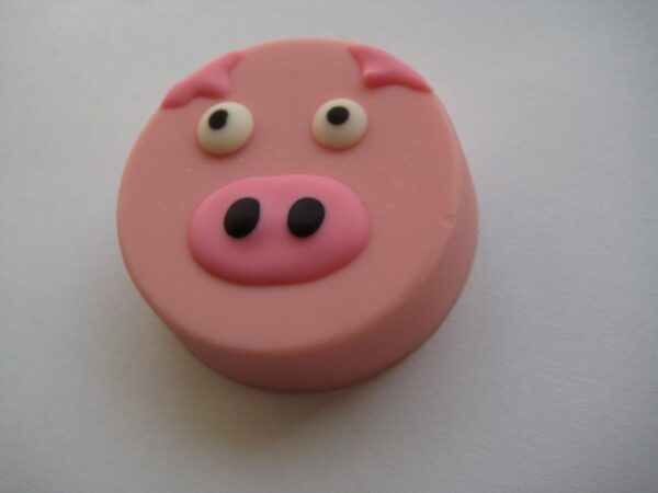 The product is "24-Pink Pig Chocolate Covered Oreo Favors," featuring a round, pink pig face with large eyes and a snout on a flat surface.