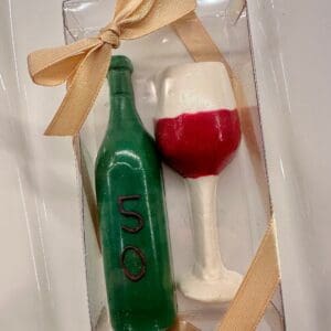 A gift set of 12 chocolate wine glasses and wine bottles in a clear box with a beige ribbon, perfect for birthdays, anniversaries, or weddings.