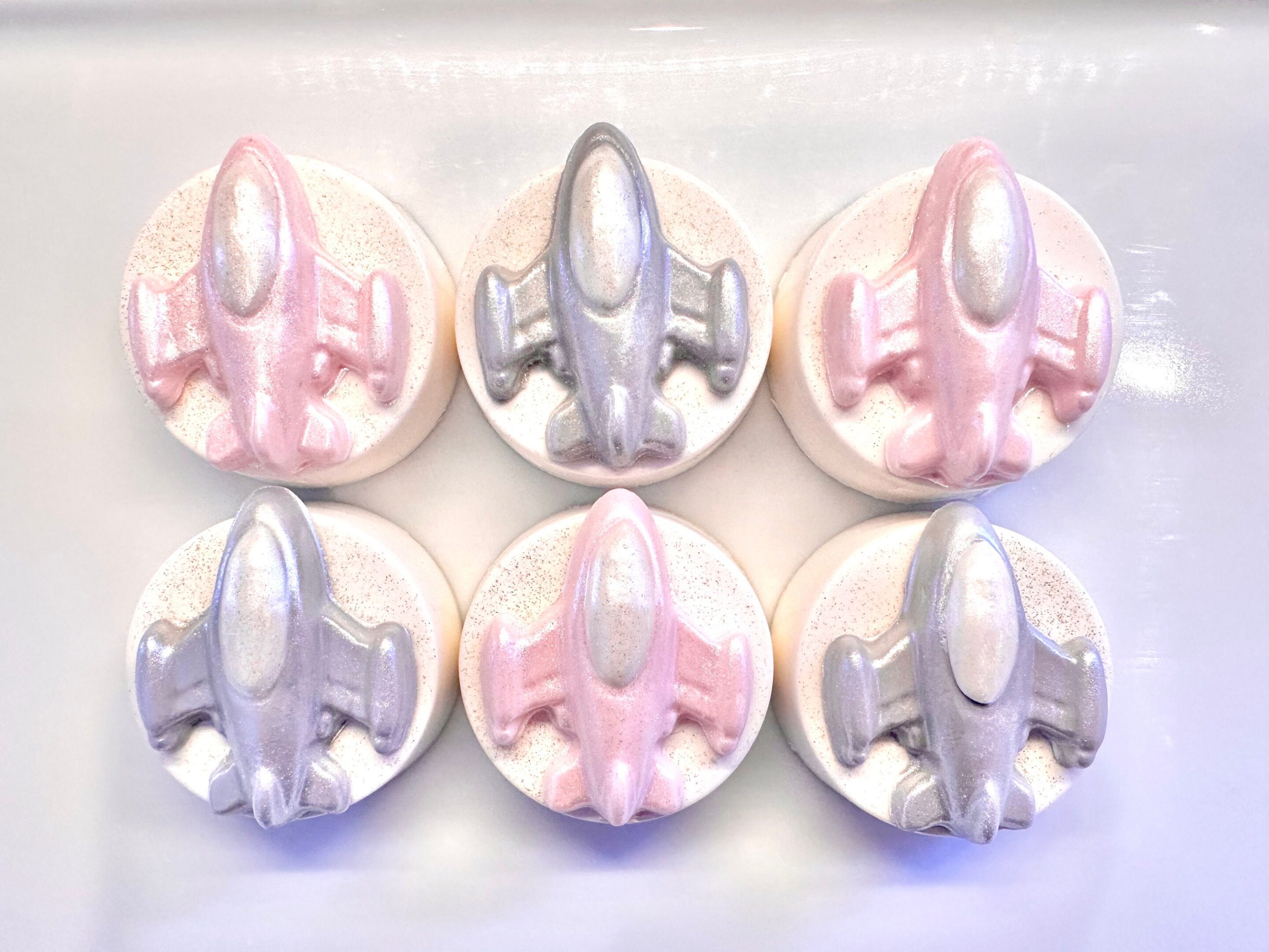 A dozen chocolate-covered Oreo favors, shaped like spaceships, perfect for a space-themed birthday party.