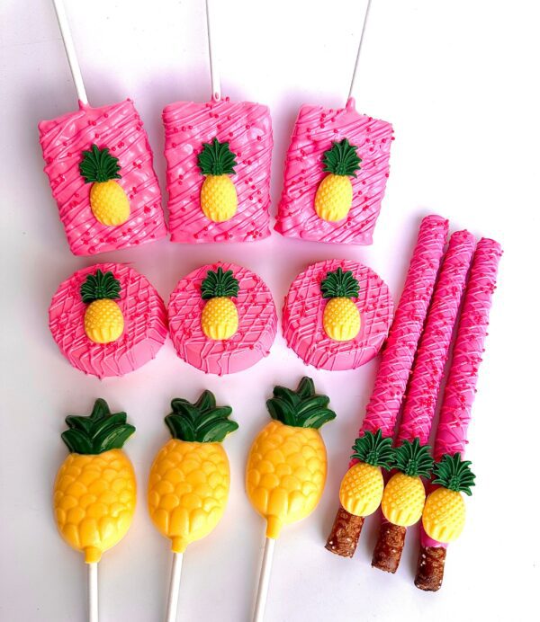 The 48 Piece Pink Pineapple Treat Package for Birthday Parties features pink and yellow pineapple-themed sweets, including pretzel sticks, cookies, and lollipops arranged on a white background.