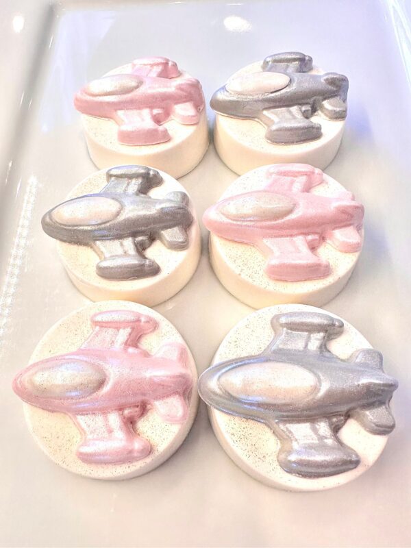 Six airplane-shaped cookies with pink and silver icing, arranged on a white rectangular tray, from the 12-Spaceship Chocolate Covered Oreo set for birthday parties or space-themed events.