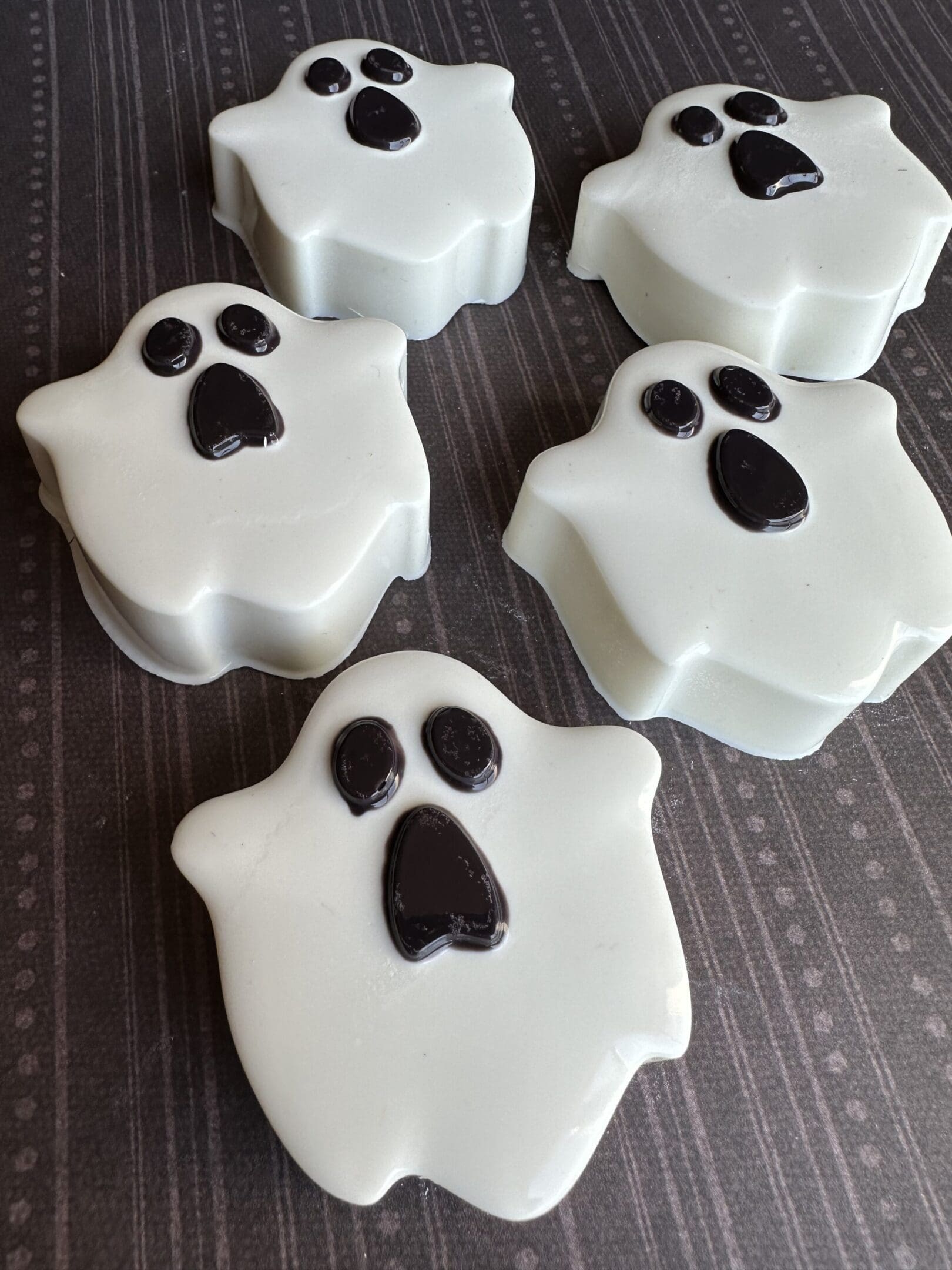 Ghost-shaped soaps on a dark surface.