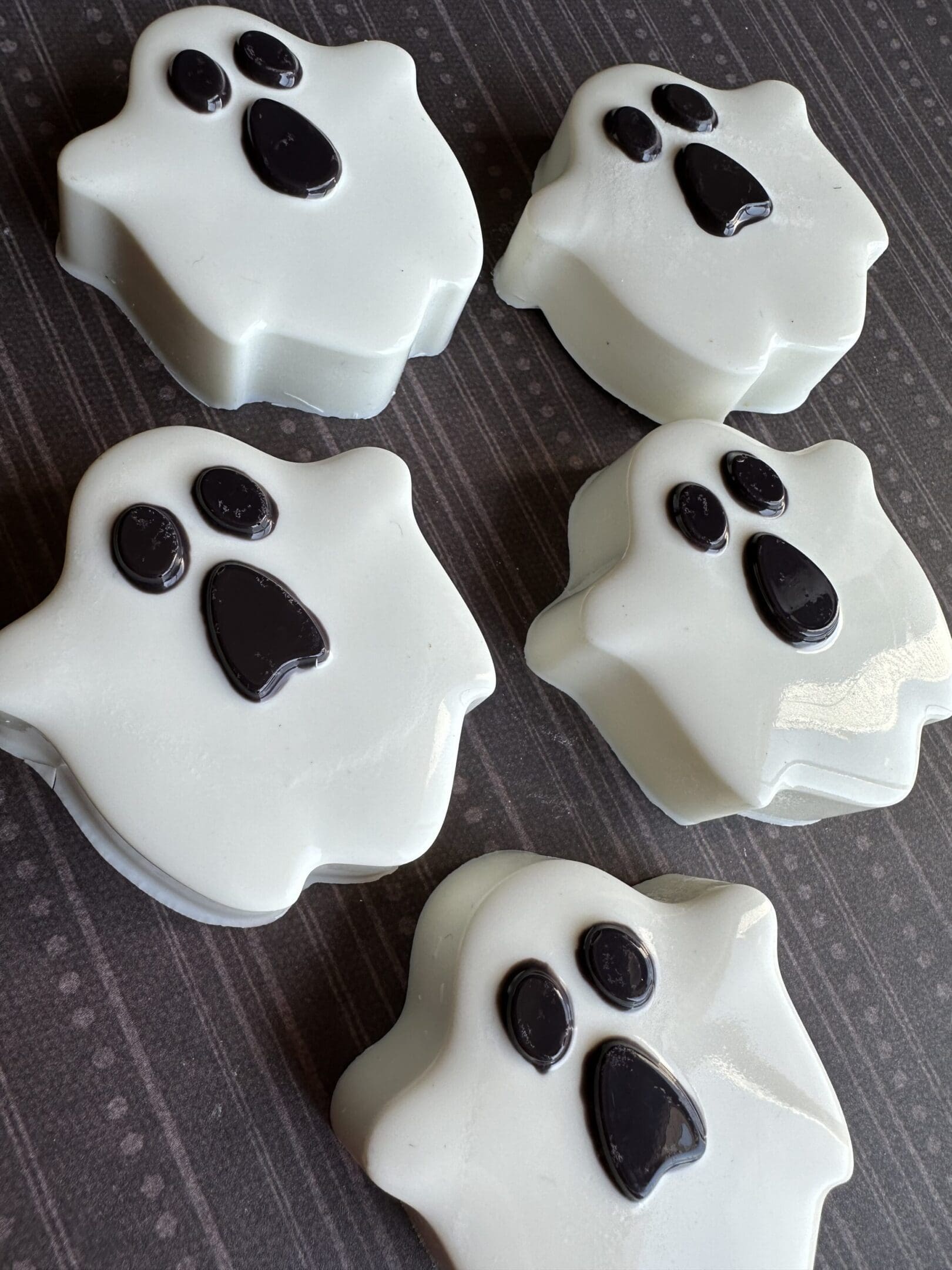 Ghost-shaped cookies on a dark table.
