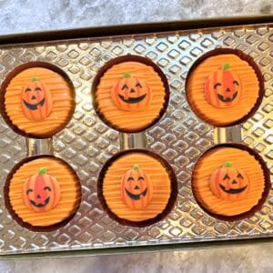 Pumpkin-themed chocolates in a decorative box.