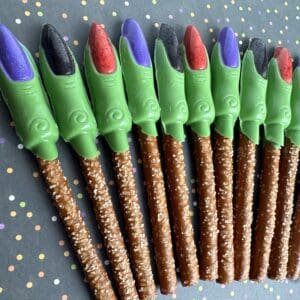 Colorful pretzel sticks with witch finger toppers.