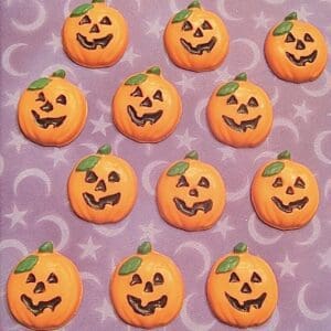Smiling pumpkin candies on purple background.